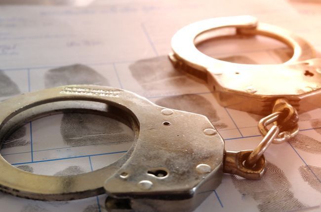 Handcuffs over fingerprints on intake form